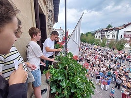 Los jóvenes del Gazteleku lanzando el txupinazo desde el balcón en la tarde de ayer.