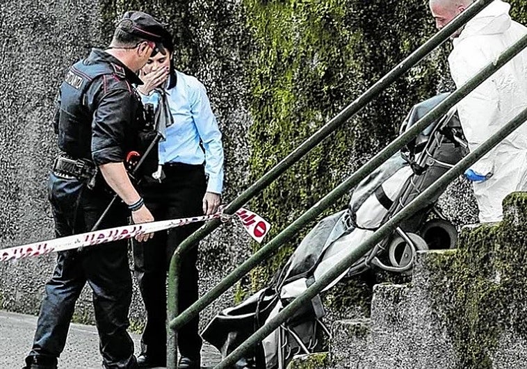 Ertzainas y responsables de la investigación trasladan uno de los cadáveres
