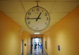 Un reloj indica la hora en el pasillo de un hospital con camas para cuidados paliativos.