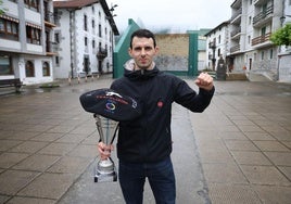 Jokin Altuna, en Amezketa, alza el puño en señal de victoria mientras sujeta el trofeo y la txapela que le acreditan como campeón.