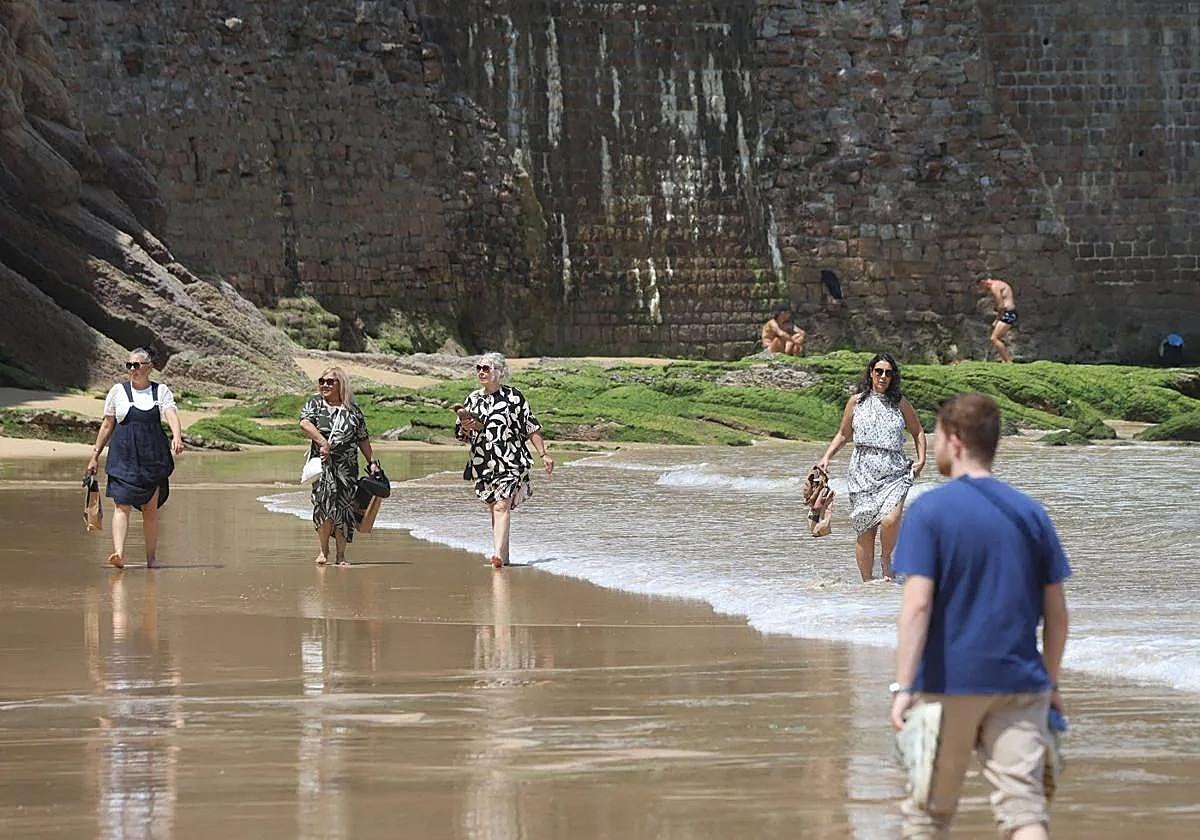 Varias mujeres pasean por la playa de Ondarreta, en Donostia.