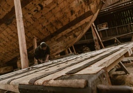 Un operario reconstruye la puerta del Santuario de San Miguen en la factoría Albaola