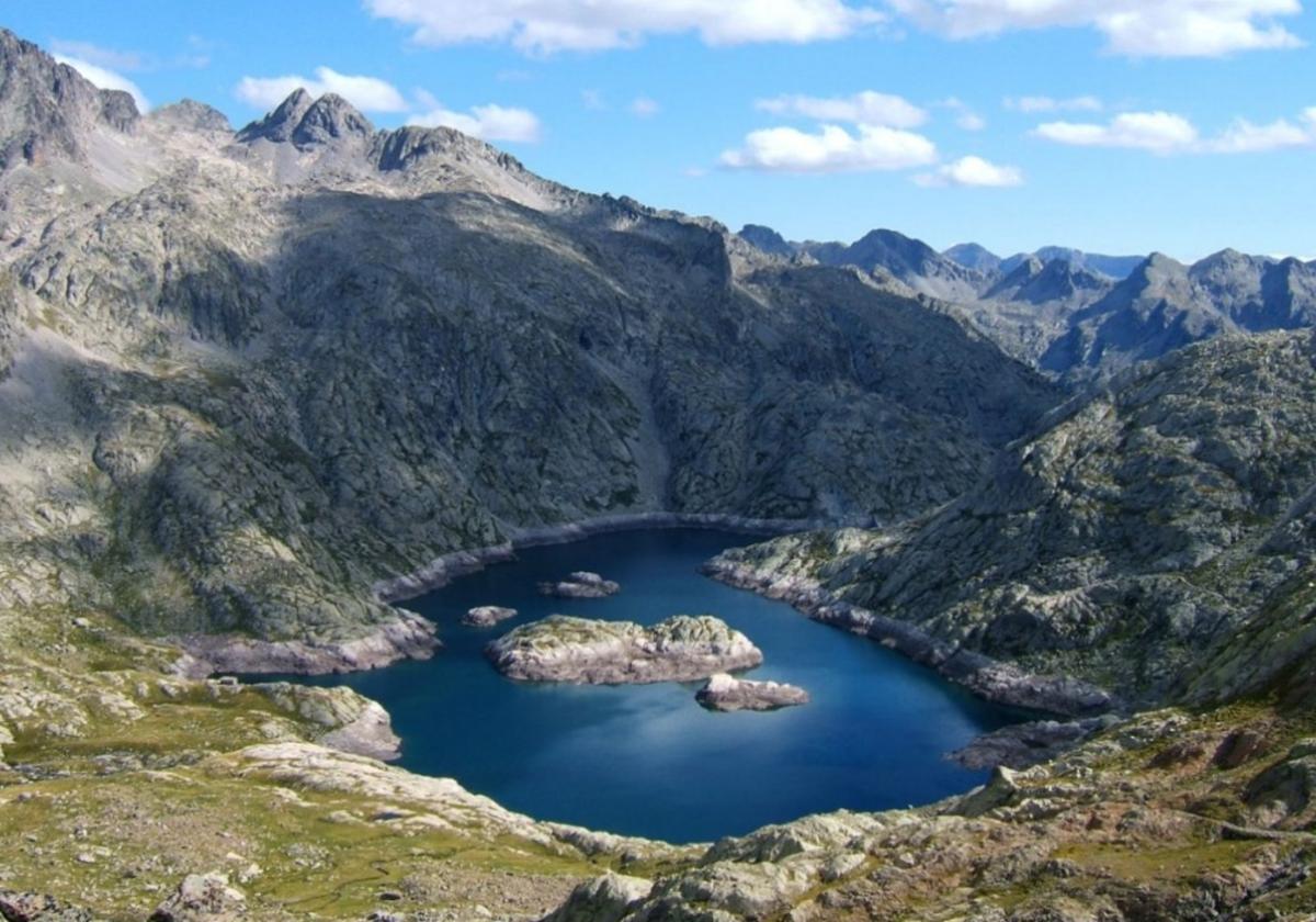 Vista del Lac de Néouvielle, rodeado de picos graníticos en el corazón de la Reserva Natural de Néouvielle, Pirineos franceses.