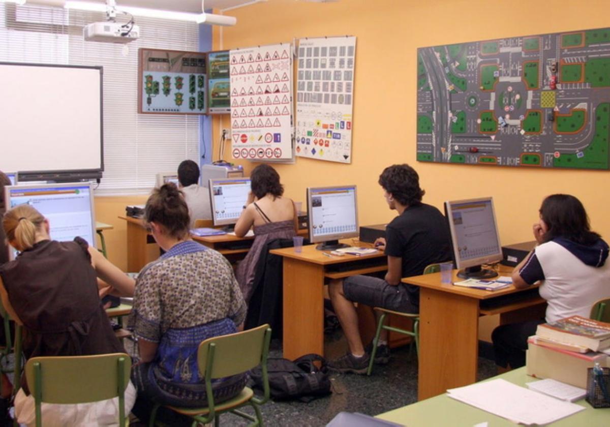 Hainbat pertsona autoeskola batean ikasten, gidabaimena ateratzeko.
