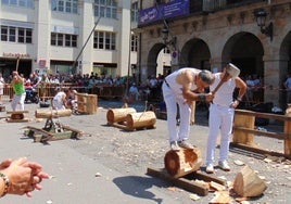 El osintxuarra Paulo Azpiazu en pleno esfuerzo con una piedra irregular. Desafío de aizkolaris entre jóvenes y mayores. El veterano Ernesto Ezpeleta 'Bihurri' en el corte a una mano.