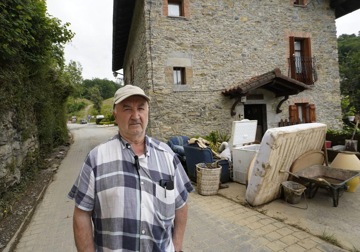 Dámaso Zubeldia, con el montón de muebles y herramientas apilado frente a la puerta de su casa