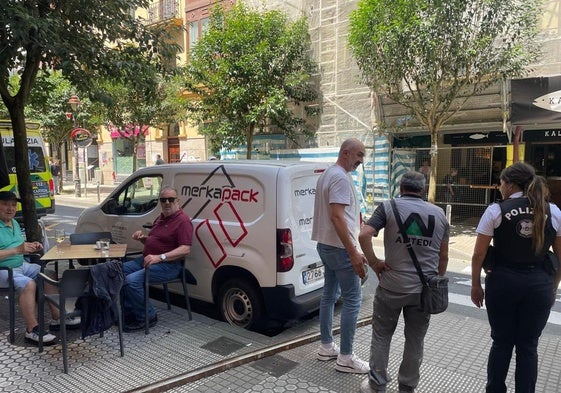 Varios clientes observan la barra metálica caída sobre la acera en la calle Matia de Donostia y que ha golpeado a un hombre.