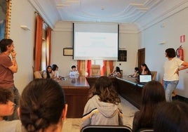 El alcalde (a la izquierda) y la técnica municipal escucharon a los alumnos de Lezo Institutua durante la presentación en el salón de plenos.