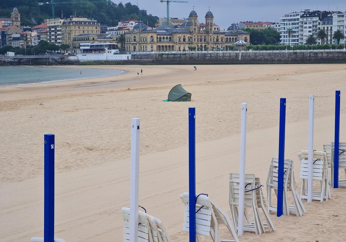 Debieron comprar entradas para el concierto de Bruce Springsteen y se quedaron sin dinero para el alojamiento. Así amaneció el viernes la playa de La Concha, con una tienda de campaña instalada frente a los Relojes. Sus ocupantes ni se inmutaron con el paso de los camiones de limpieza y la cribadora encargada de recoger residuos en la playa.