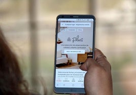 Una usuaria consulta la web de Airbnb en el móvil.
