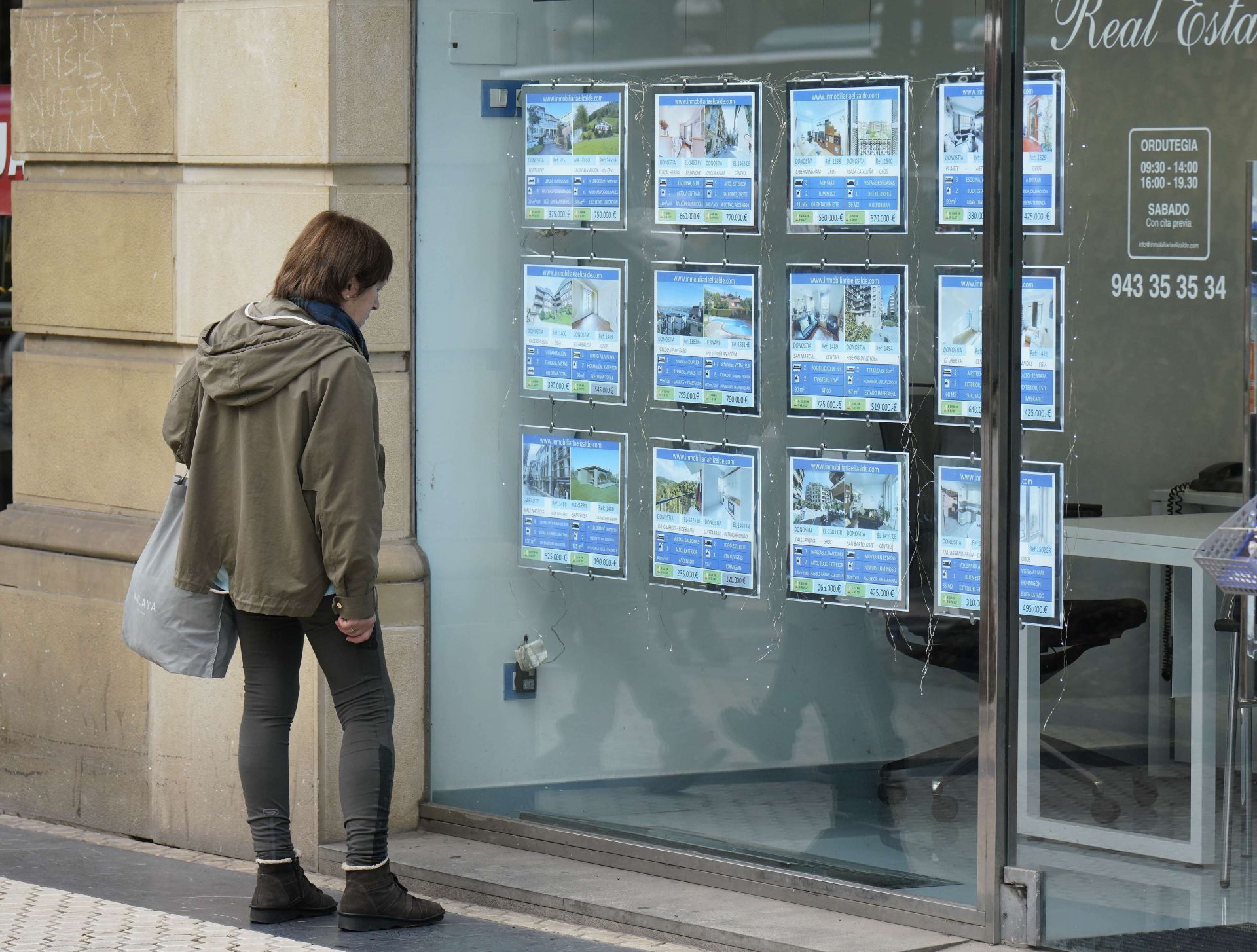 Una mujer frente al escaparate de una inmobiliaria en Gipuzkoa.