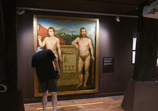 Un espectador contempla el escudo pintado por Eugenio de Azkue.