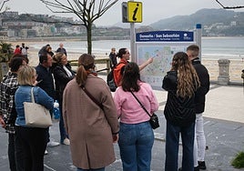 Un guía turístico da indicaciones a un grupo en la playa de La Concha.