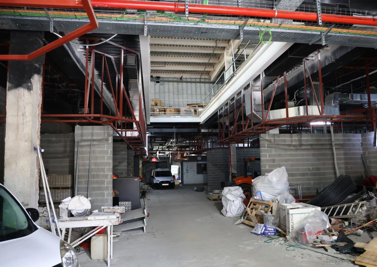 Imagen secundaria 1 - La concejala Ane Oyarbide y el director de Fomento, Iñigo Olaizola, visitan las obras. Debajo, planta baja de Pescadería, donde se instalarán los asentadores, y túnel de acceso al parking con el local que ocupará el gimnasio Fitness Park.