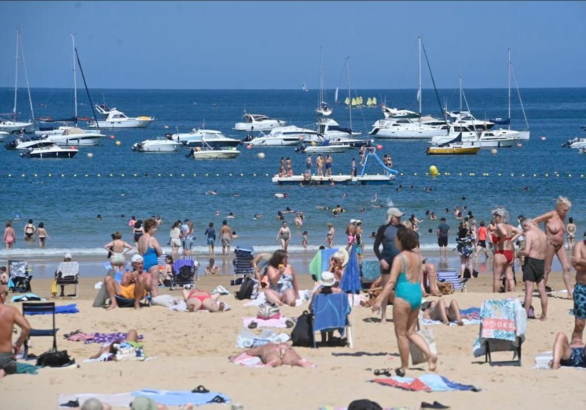 Vista de la playa de La Concha repleta de gente y varios barcos fondeados este viernes por la mañana.