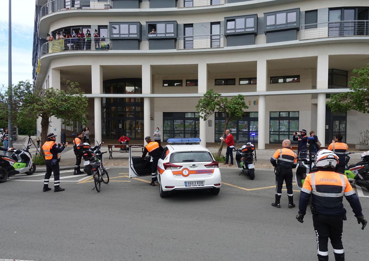 Imagen secundaria 1 - El bus turístico, atascado en el paseo Salamanca por culpa de una furgoneta que sobresale de la plaza de aparcamiento. Debajo, el agente Igor Ayerdi se baja del coche patrulla para felicitar un cumpleaños durante el confinamiento y dos agentes conversan con una mujer en la Parte Vieja en el primer día del cuerpo, en 2009. 