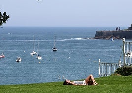 Una joven disfruta del sol en los jardínes del Palacio de Miramar, en San Sebastián.
