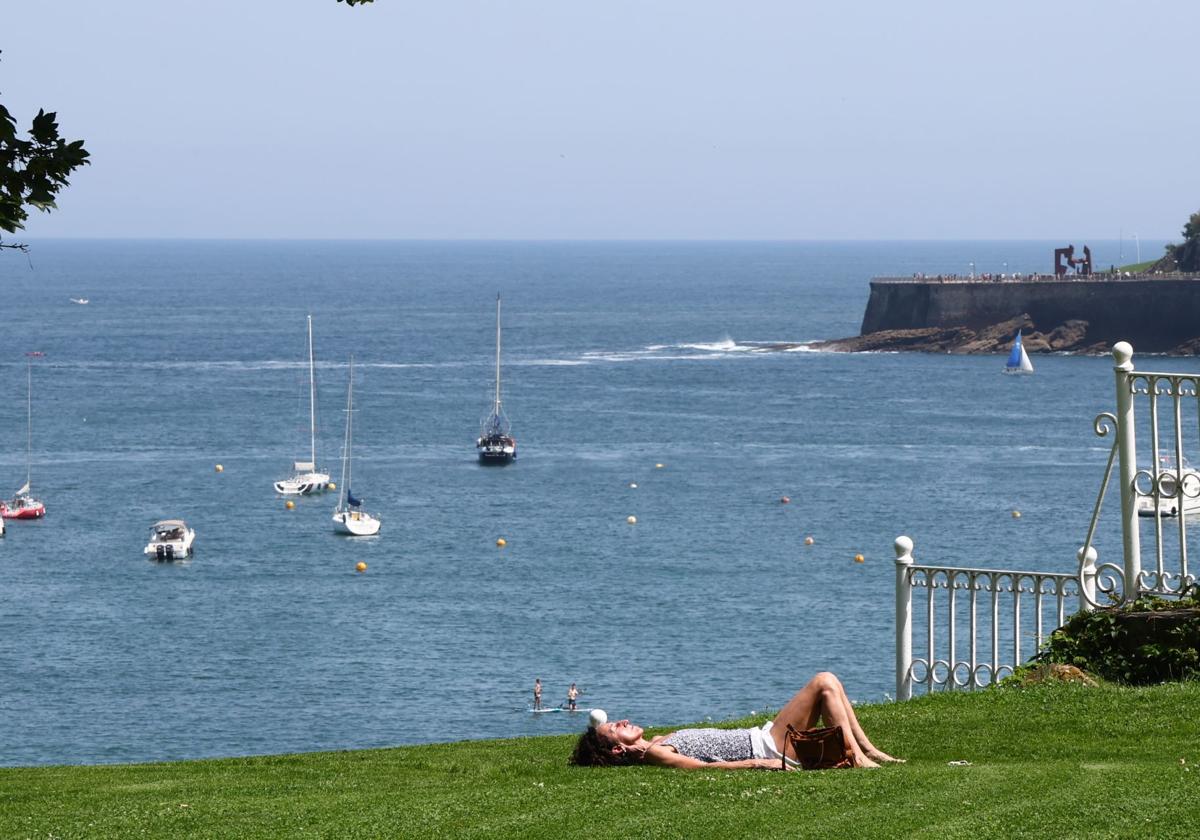 Una joven disfruta del sol en los jardínes del Palacio de Miramar, en San Sebastián.