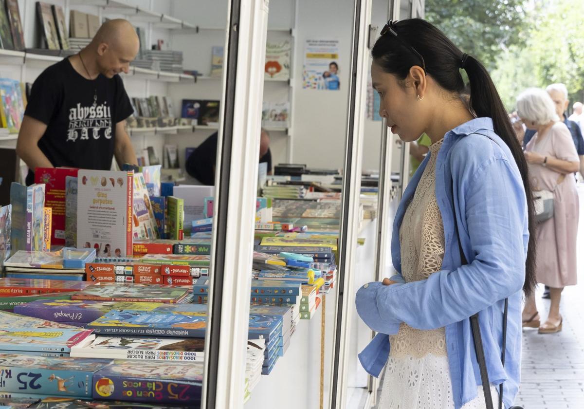 Una joven se pasea por uno de los stands de la Feria del Libro de Donostia.