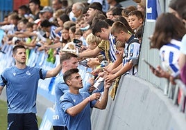 Barrene, Sergio Gómez y Zubeldia firman autógrafos este martes ante las decenas de niños apilados en la valla