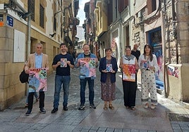 Los representantes de los distintos grupos posan con el programa.