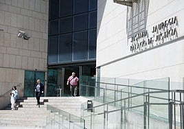 Tres personas salen del Palacio de Justicia de San Sebastián, en el barrio de Egia.