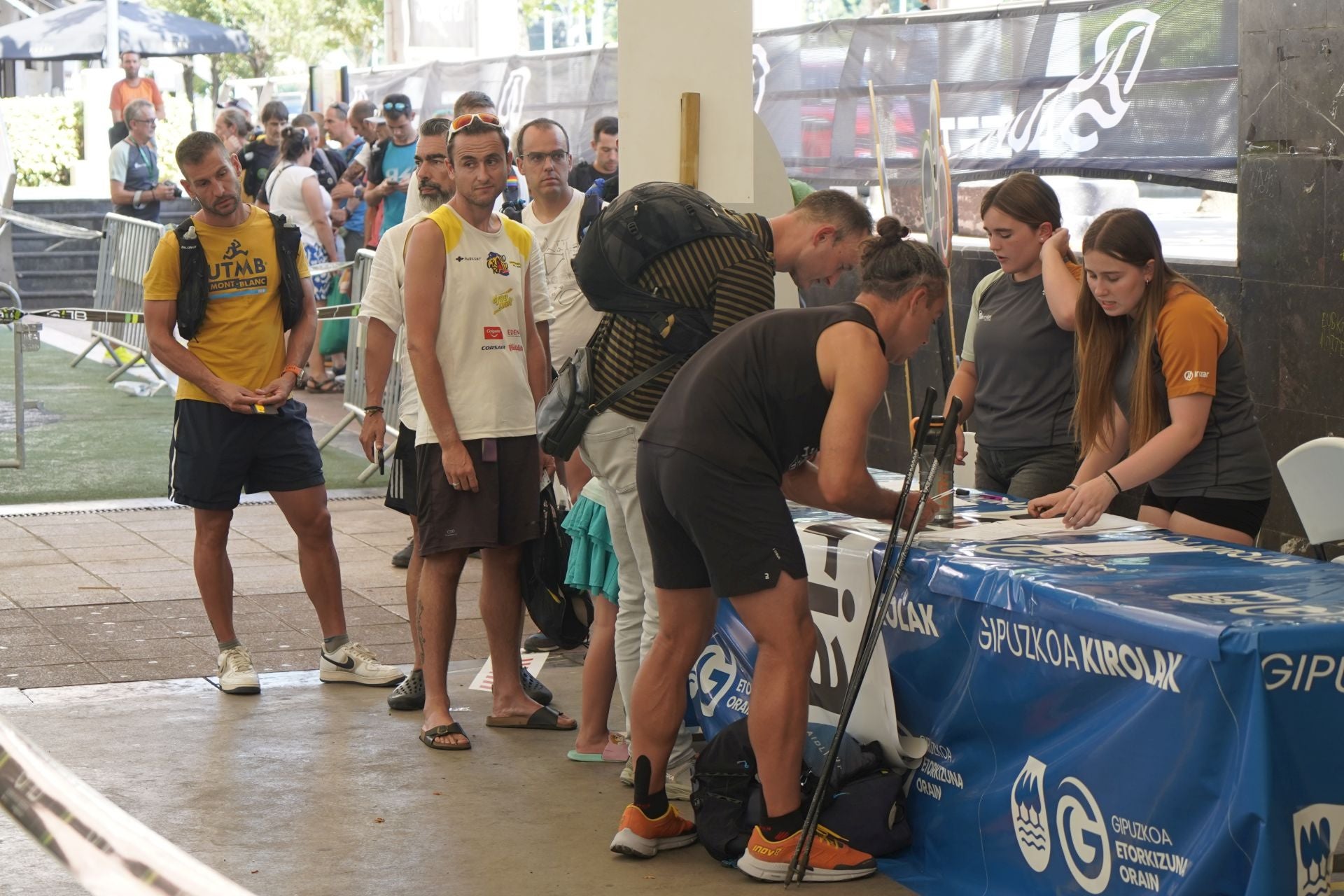Los corredores recogen sus dorsales.