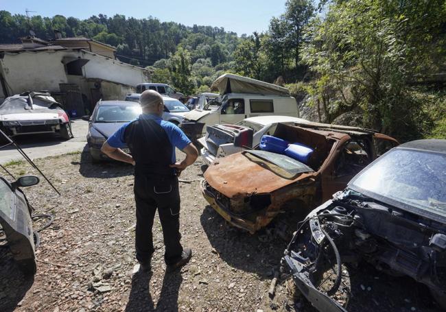 José Carrera observa los coches que fueron arrastrados desde su taller, donde iban a ser arreglados, hasta un hoyo.