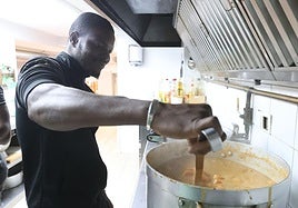 Refugiado maliense cocina el plato típico conocido como maffe