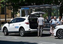 Un taxista atiende a una clienta que está a punto de subirse a su vehículo en la parada del Boulevard donostiarra.