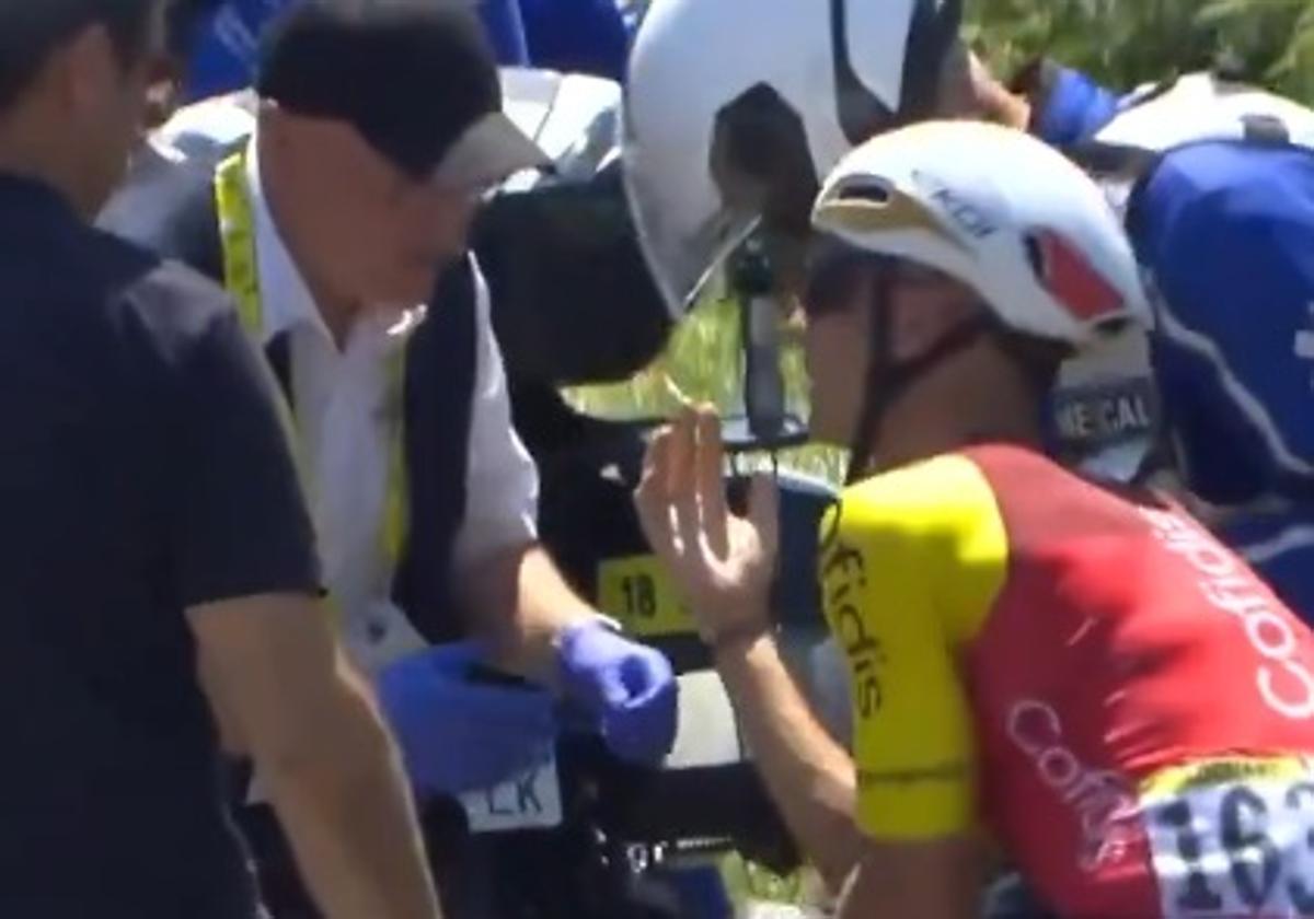 Bryan Coquard siendo atendido y mostrando al médico la mano lesionada en el incidente.