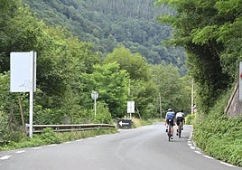 Dos ciclistas pasan, este sábado a la mañana, por el lugar en el que se produjo el atropello mortal.