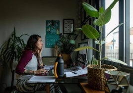 Una mujer realiza teletrabajo en su casa.