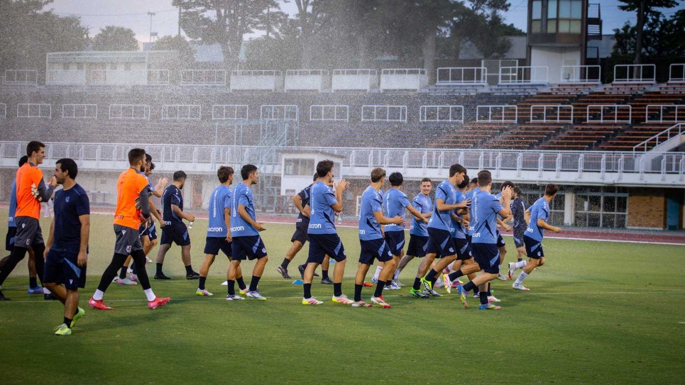 Los jugadores de la Real calientan en los primeros minutos del entrenamiento de ayer.