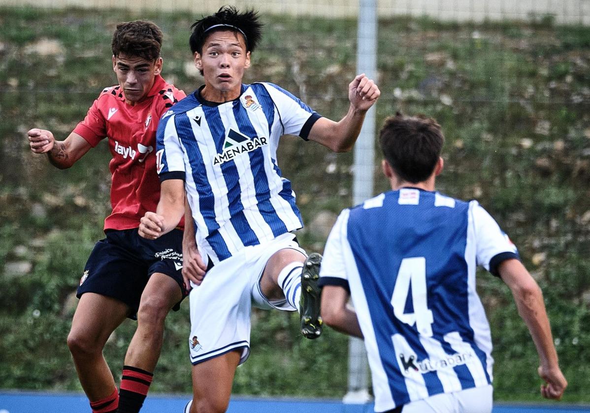 Kazunari Kita, pugnando por un balón aéreo con un rival.