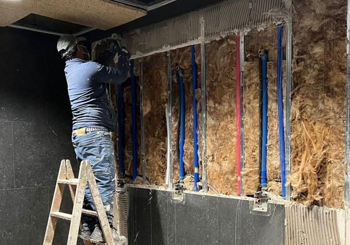 Un trabajador durante la instalación de una ducha.