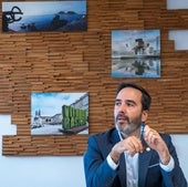 Javier Hurtado, durante la entrevista en una sala con imágenes de atractivos turísticos, entre ellos el Peine del Viento de Donostia.