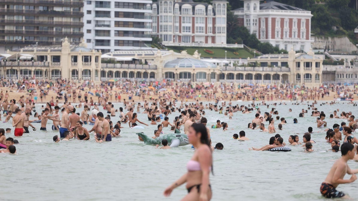 Varias personas se bañan en la playa de La Concha, en Donostia