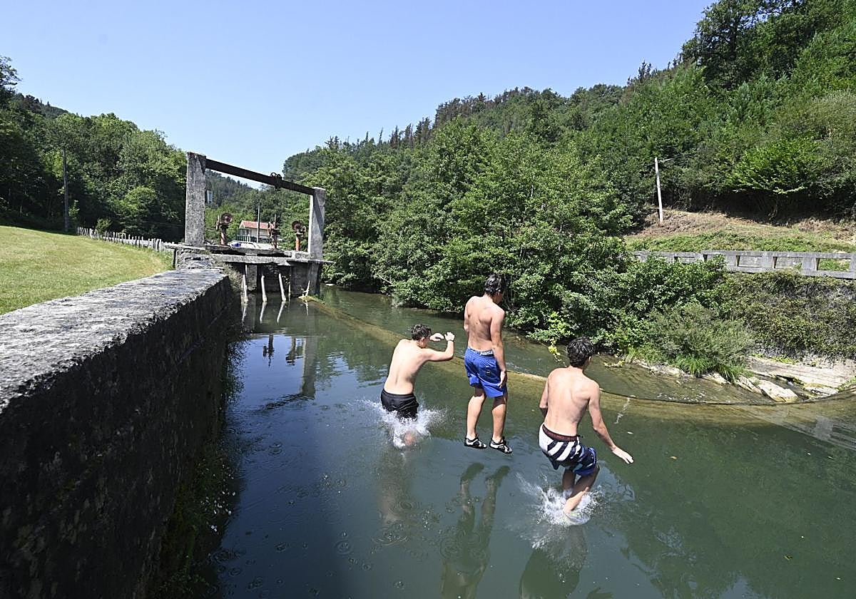 Varios jóvenes se refrescan en una presa del río Araxes en Lizartza.