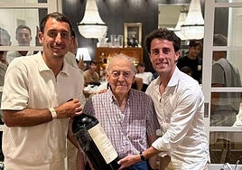 Oyarzabal y Odriozola sujetan una gran botella de vino junto a Txomin Rekondo, propietario del restaurante, con Guedes, entre otros, por detrás