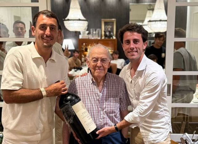 Oyarzabal y Odriozola sujetan una gran botella de vino junto a Txomin Rekondo, propietario del restaurante, con Guedes, entre otros, por detrás