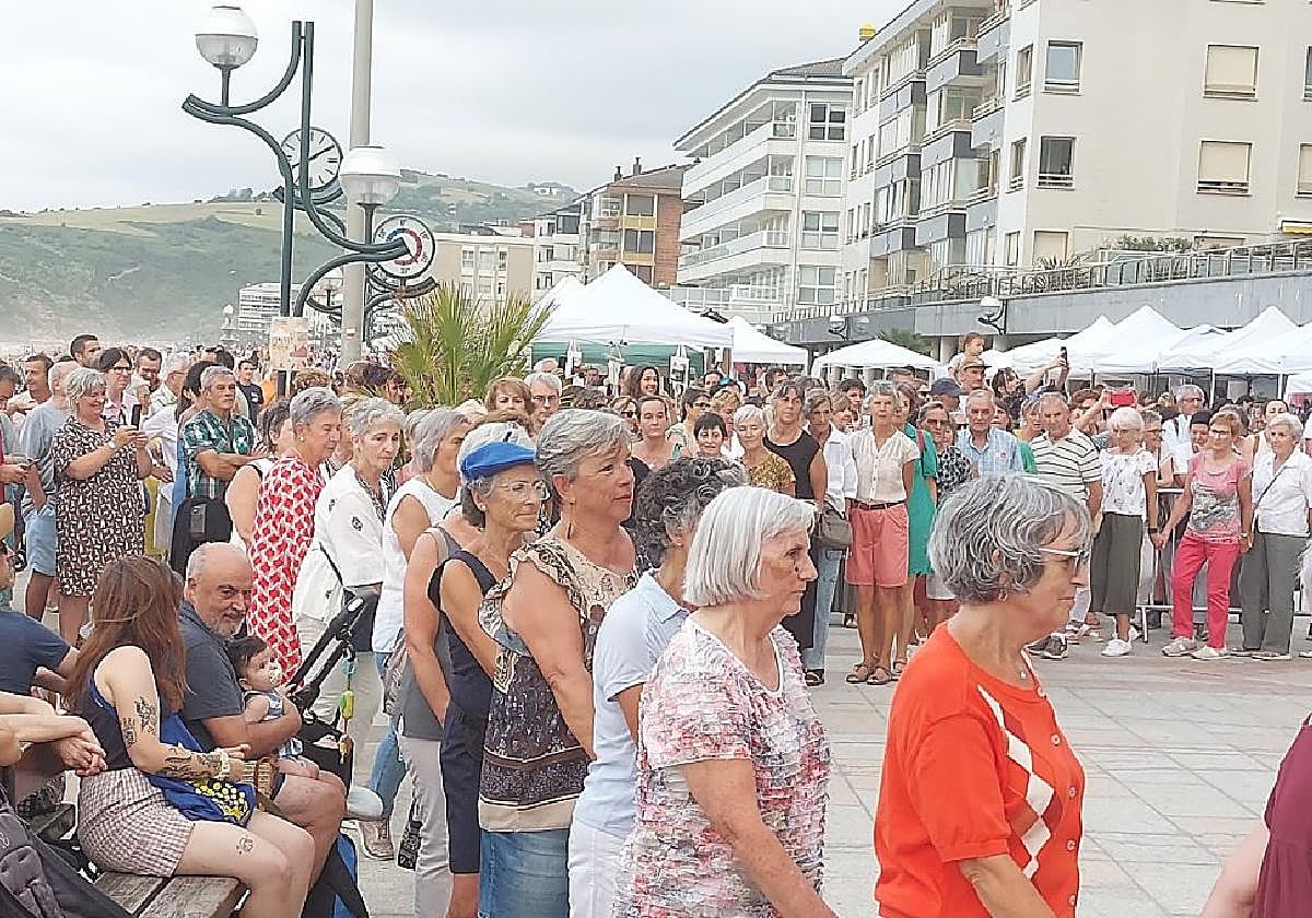Los dantzaris junto al público congregado en el malecón para dar a conocer a turistas y visitantes las costumbres locales.