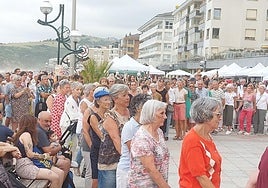 Los dantzaris junto al público congregado en el malecón para dar a conocer a turistas y visitantes las costumbres locales.