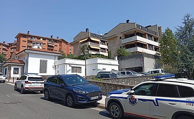 Coches de la Ertzaintza en la calle Bikuña, donde ha sido hallado el cadáver, dentro de un local
