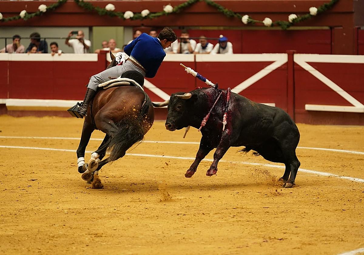 Caballo castaño, toro negro, caballero vestido de corto, banderillas blanquiazules. Triunfa Guillermo.