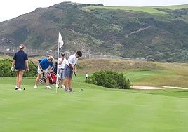 Varios jugadores en uno de los hoyos del campo de golf.