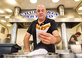 Arturo Manchado sirve media docena de churros a un cliente en su churrería de la Plaza Easo.