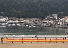 Los miembros de Vox agarran la bandera en el arenal donostiarra este martes.