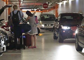 Unos turistas sacan sus maletas de un vehículo en el parking de La Concha.