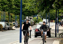 Dos jóvenes circulan en bicicleta por las cercanías del río Oiartzun.